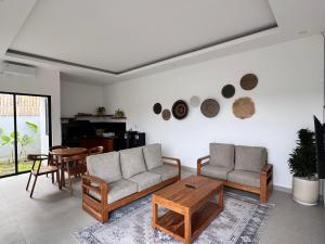 a living room with a couch and a table at Aloka Villa -Stylish 2 bedroom villa in the heart of Seseh in Munggu