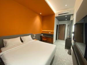 una camera da letto con un letto bianco e una scrivania di D'Capstone Guesthouse a Nagoya Altre 2 foto