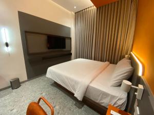 una camera d'albergo con un letto e una tv di D'Capstone Guesthouse a Nagoya