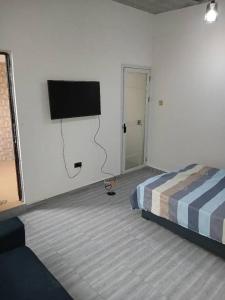 a bedroom with a bed and a flat screen tv at Guest Apartments in New Weija