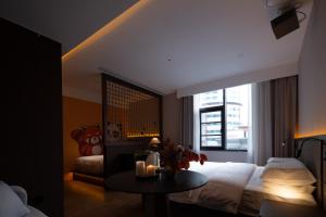 成都市にあるThe Panda Artisan, Taikoo Li Xilia Hotelのベッドルーム1室(ベッド1台、キャンドル付きテーブル付)