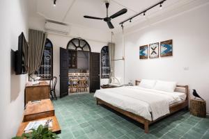 ein Schlafzimmer mit einem Bett, einem Fernseher und einem Tisch in der Unterkunft Prime Retreat - Near Hoan Kiem Lake - Balcony in Hanoi