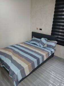 a bed with blue pillows in a bedroom at Guest Apartments in New Weija