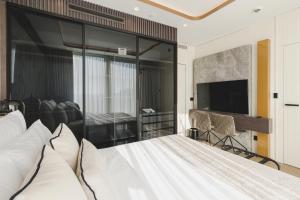 Un dormitorio con una cama y un televisor de pantalla plana. en Luminoso Boutique Hotel, en Budva