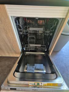 a dishwasher with its door open in a kitchen at Chalet La Diga in Mariënberg +37 photos