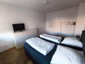 a bedroom with two beds and a tv on the wall at Business Apartment Chemnitz in Chemnitz