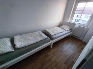a small room with two beds and a window at Business Apartment Chemnitz in Chemnitz