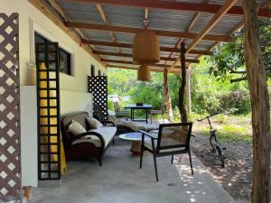 a patio with a couch and chairs under a pergola at Filo La Union in San Juan