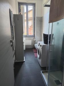 een kleine badkamer met toilet en raam bij Appartamenti Lungo Fiume 506 in Sesto Calende