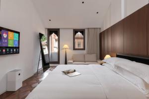 a bedroom with a large white bed and a couch at Floral Hotel Gaosheng in Zhangzhou