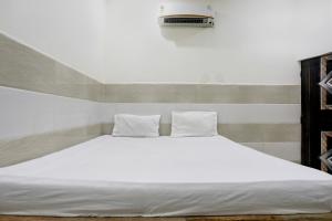 a large white bed with two pillows on it at Hotel O The Starlight in Ghaziabad +24 photos
