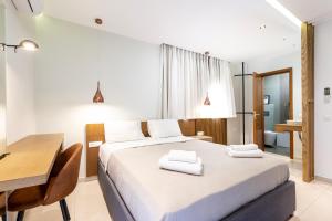 a bedroom with a bed and a table and a desk at INFINITY PREMIUM Villas in Kos Town +152 photos