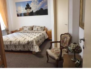 a bedroom with a bed and a chair at Apartment UNA - self check in in Graz
