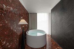 a bath tub in a room with a lamp at Floral Hotel Gaosheng in Zhangzhou +69 photos