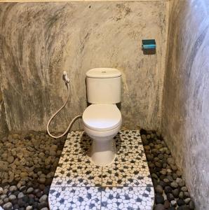 - une salle de bains avec toilettes dans une chambre ornée de rochers dans l'établissement Sejooq Cottages, à Tetebatu 11 autres photos