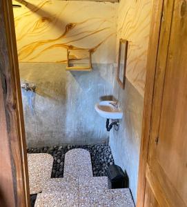 une petite salle de bain avec un lavabo et des toilettes dans l'établissement Sejooq Cottages, à Tetebatu