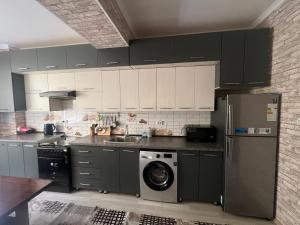 eine Küche mit einem Kühlschrank und einer Waschmaschine in der Unterkunft Уютная 2-х комнатная квартира 82м2 в Центре города! in Buxoro + 8 Fotos