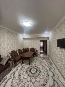 ein Wohnzimmer mit Sofa und Tisch in der Unterkunft Уютная 2-х комнатная квартира 82м2 в Центре города! in Buxoro
