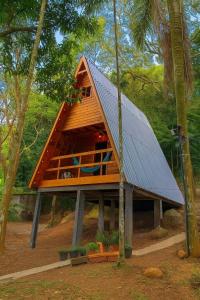 a house with a metal roof in the woods at Chalé com jacuzzi Florianópolis in Florianópolis