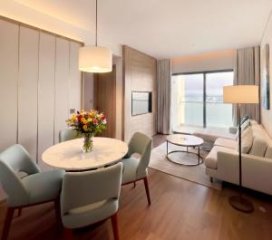 un salon avec une table et des chaises dans l'établissement HB Serviced Apartment - Alacarte Hạ Long, à Hạ Long