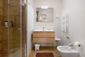 een witte badkamer met een wastafel en een douche bij Gold - Il Centro Luxury Suites in Bari +16 foto's