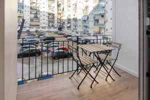 een balkon met een tafel en uitzicht op een parkeerplaats bij Gold - Il Centro Luxury Suites in Bari