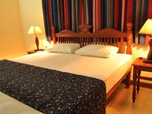 une chambre avec un grand lit avec deux oreillers dans l'établissement Lake View Bungalow Yala, à Tissamaharama