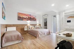 een slaapkamer met 2 bedden en een bureau bij Gold - Il Centro Luxury Suites in Bari