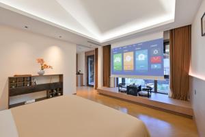 ein Wohnzimmer mit einem großen TV und einem Bett in der Unterkunft Datong Songque Homestay in Datong