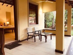 une terrasse avec 2 chaises et une table sur une maison dans l'établissement Lake View Bungalow Yala, à Tissamaharama