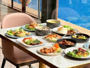 a table with many plates of food on it at Miloft Suvarnabhumi Airport Hotel in Lat Krabang