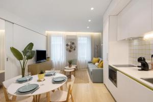 eine Küche und ein Wohnzimmer mit Tisch und Stühlen in der Unterkunft T1 Moliceiros Centro de Aveiro in Aveiro