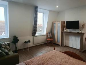 a bedroom with a bed and a tv and two windows at Secteur digue Dunkerque, Escale a Malo, Aquae Mare in Dunkerque