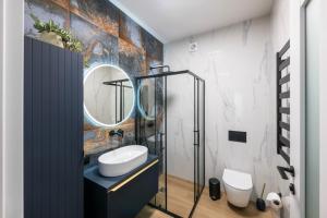 une salle de bain avec un lavabo et un miroir dans l'établissement Cottage Luxe Žaliakalnis, à Kaunas 26 autres photos