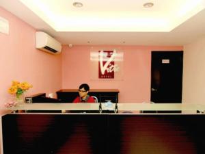 a person sitting at a desk in an office at Vitro Hotel in Johor Bahru