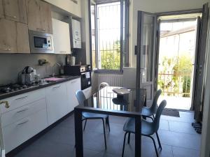 a kitchen with a table and chairs in a kitchen at Appartamenti Lungo Fiume in Sesto Calende