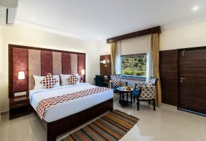a hotel room with a bed and a table and chairs at Jal Dhara Resort in Kumbhalgarh