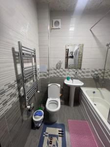 ein Badezimmer mit Toilette, Badewanne und Waschbecken in der Unterkunft Уютная 2-х комнатная квартира 82м2 в Центре города! in Buxoro