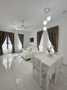 un salon blanc avec une table et un canapé dans l'établissement Stay & Rest - The Luxe Lodge, à Klang