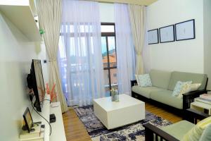 カンパラにあるThe Happy Nestのソファとテレビのあるリビングルーム