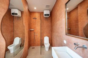 a bathroom with a toilet and a sink and a mirror at Gate 11 Spacious Apartment 1 Stylish 3rd Floor in Seminyak