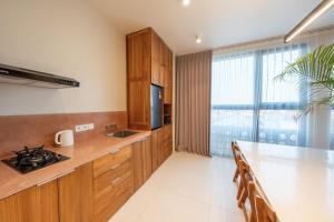 a kitchen with wooden cabinets and a large window at Gate 11 Spacious Apartment 1 Stylish 3rd Floor in Seminyak