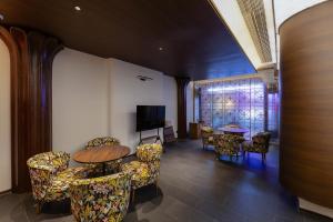 a room with a table and chairs and a television at Floral Hotel Gaosheng in Zhangzhou