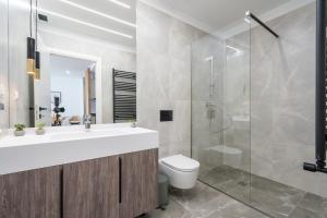 Central ONE Comfort plus Parking في بوخارست: حمام مع مرحاض بالوعة ودش +42 صورة