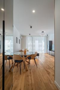 Central ONE Comfort plus Parking في بوخارست: غرفة طعام مع طاولة وكراسي زجاجية