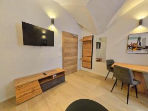 un salon avec une table et une télévision murale dans l'établissement New Two-Bedroom Apartment in the Old Town, à Hall en Tirol