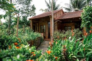 a wooden house with a pathway leading to it at Vamxang Rustic Home in Can Tho