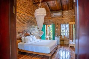 a bedroom with a white bed and a brick wall at Vamxang Rustic Home in Can Tho +93 photos
