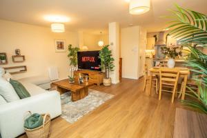 ein Wohnzimmer mit einer weißen Couch und einem Tisch in der Unterkunft 5 Star Luxury Apartment in the Heart of Galway City in Galway