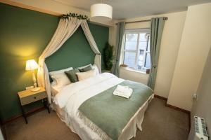 ein Schlafzimmer mit einem großen Bett mit einer grünen Wand in der Unterkunft 5 Star Luxury Apartment in the Heart of Galway City in Galway